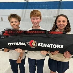 Trois élèves portant dans leurs mains un sac des Sénateurs d'Ottawa