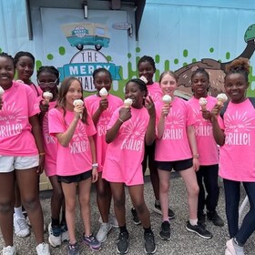Groupe de filles actives, elles portent un chandail rose et dégustent un cornet de crème glacée
